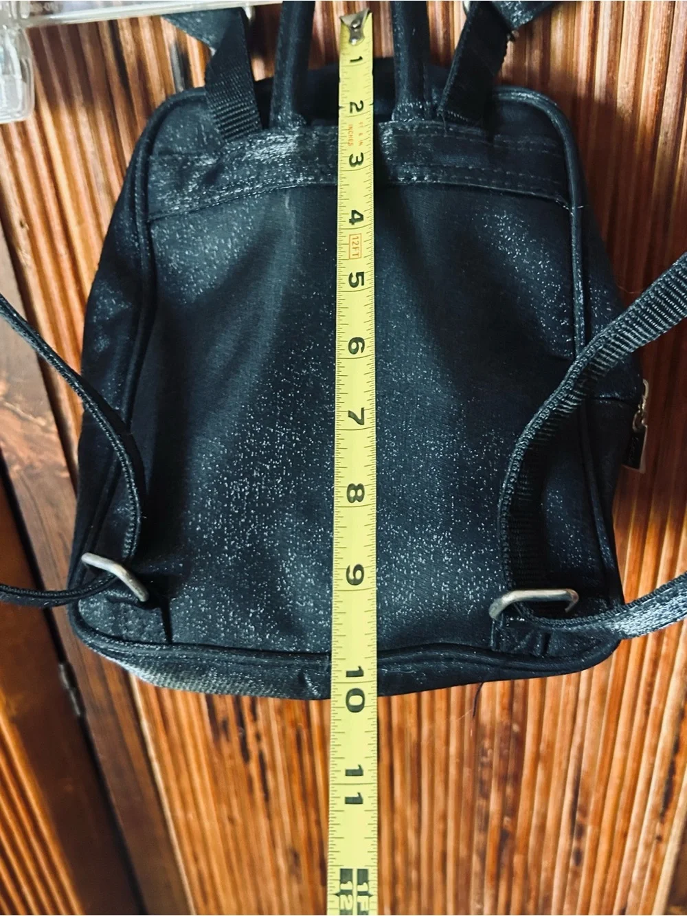 Backpack mini style. Black little purse with lots of compartments and zippers.